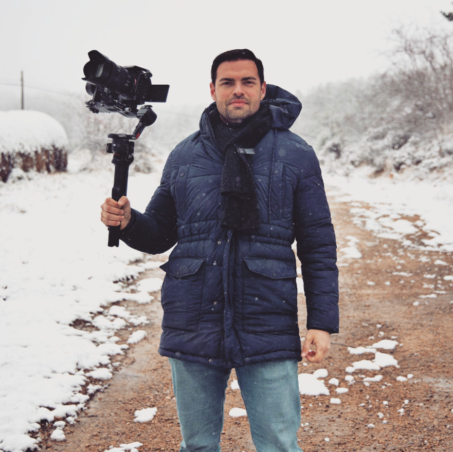 Videógrafo profesional de AGV Productions sosteniendo una cámara en un entorno nevado